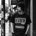 Black-and-white portrait of a man wearing a Retatrutide shirt on a city sidewalk | color:Black