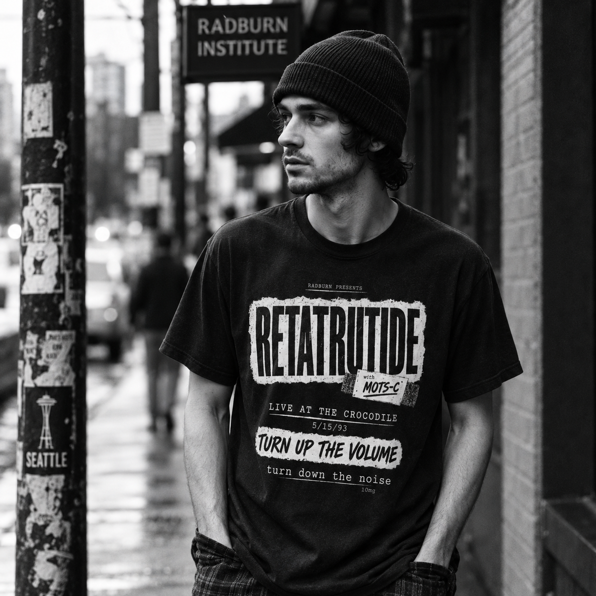 Black-and-white portrait of a man wearing a Retatrutide shirt on a city sidewalk | color:Black